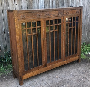 Arts and Crafts Mission Oak 3 door bookcase with three upper drawers and mullioned doors.